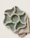 Green-edged floral arrangement of decorative dishes, supplied product image.