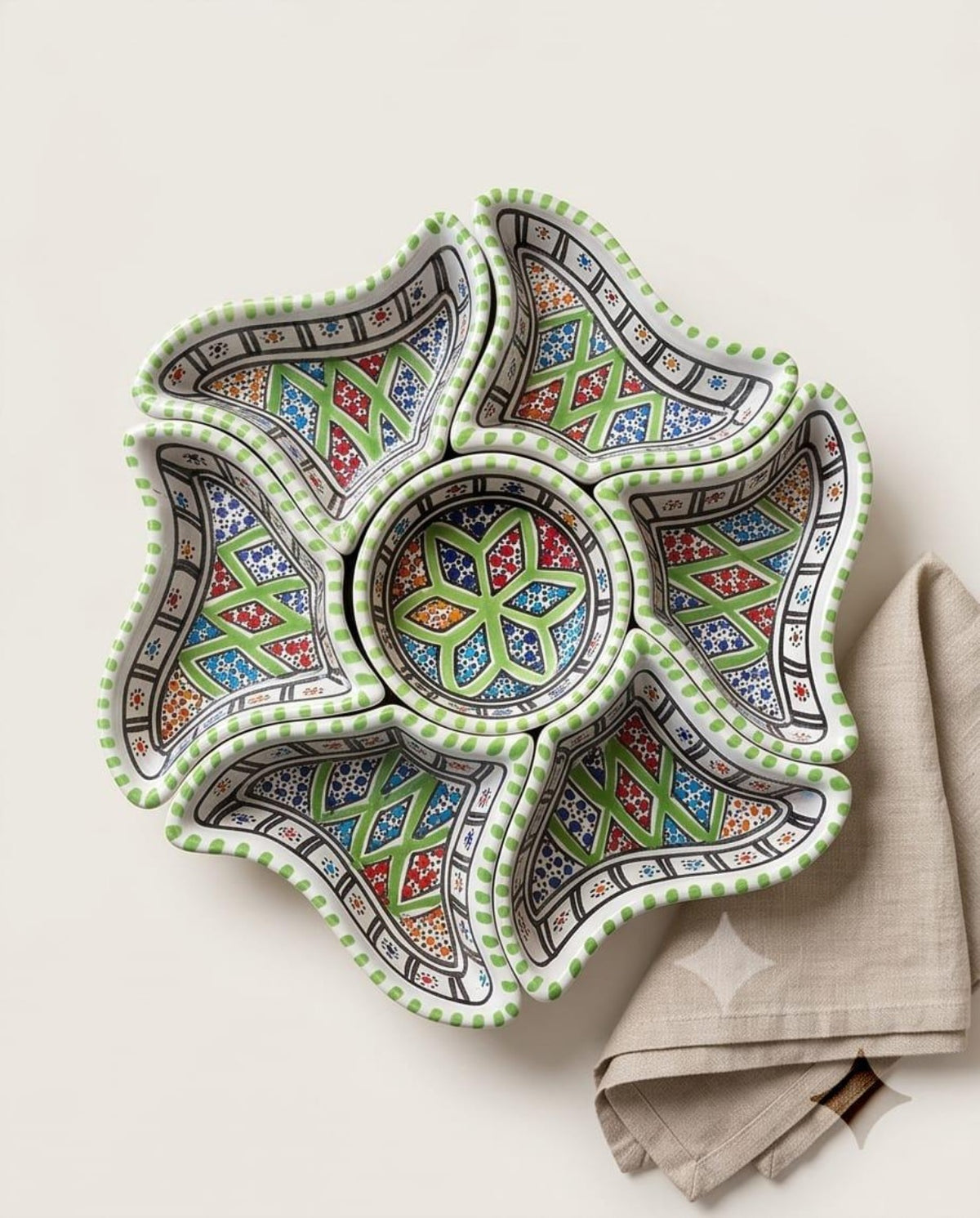 Green-edged floral arrangement of decorative dishes, supplied product image.